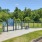 Fenced off dog park with a sign and trees in the background at Easthaven