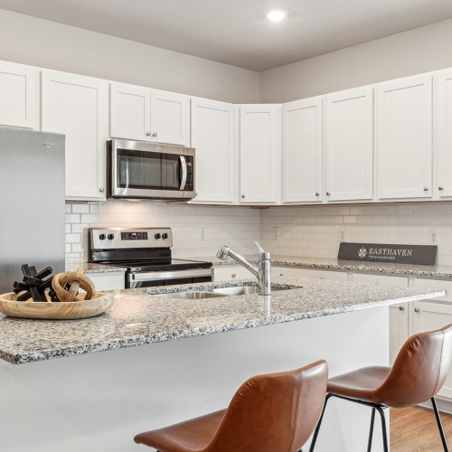 Beautiful kitchens with designer finishes Easthaven townhome kitchen with an island and seating and stainless steel appliances