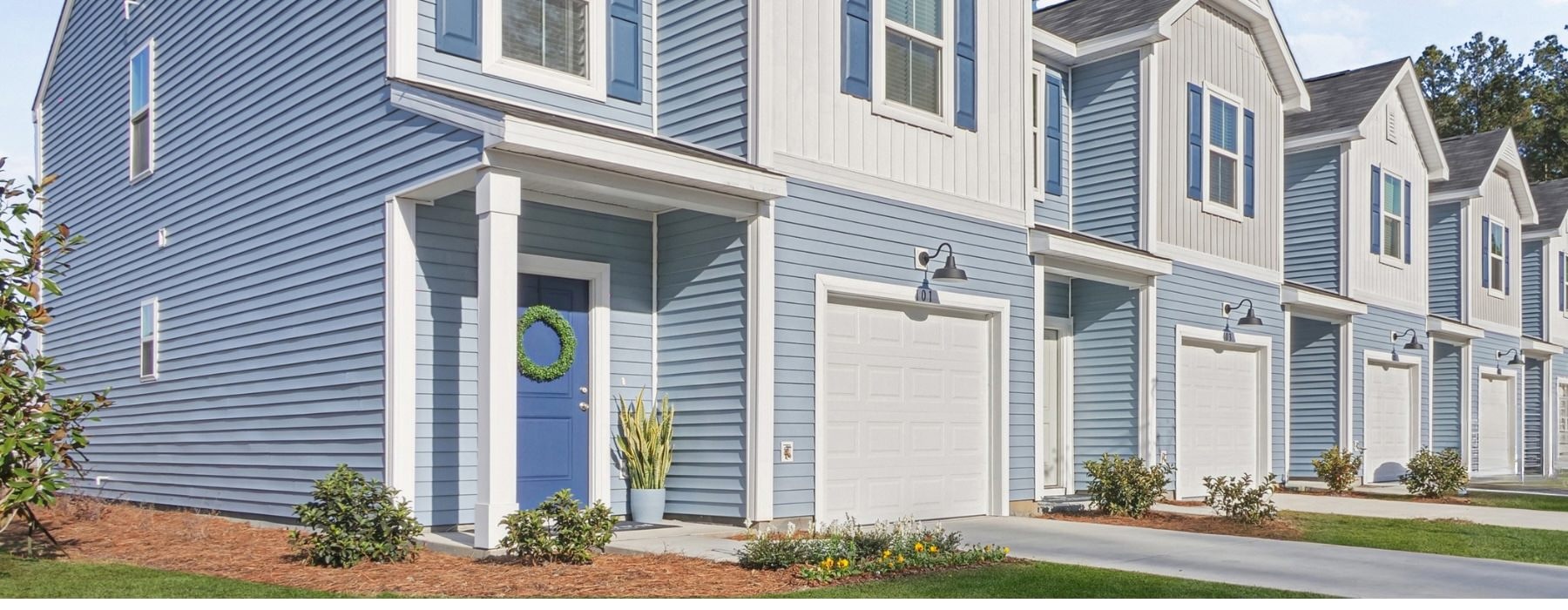 Exterior view of Easthaven's townhomes with attached single car garages and driveway